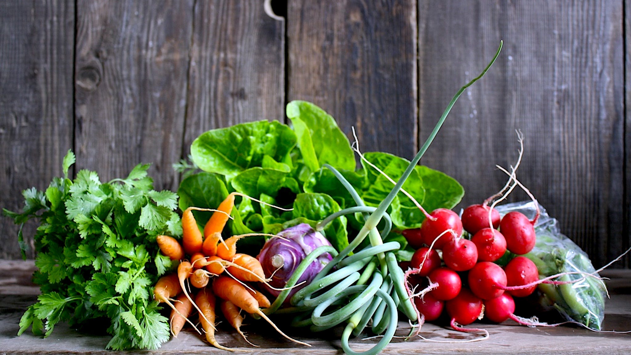Variety of certified organic vegetables displayed on a rustic wooden table