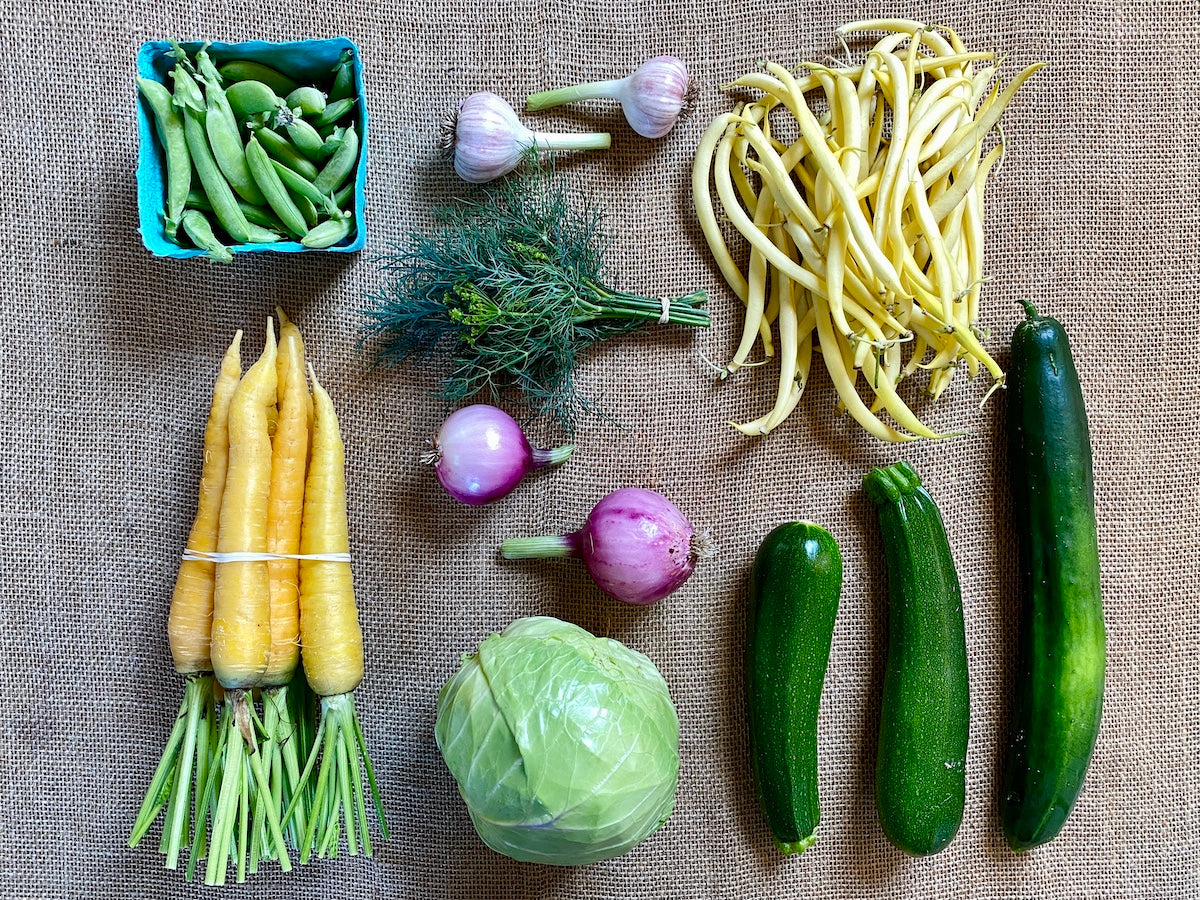 Colorful selection of certified organic vegetables in a mid-season CSA box.