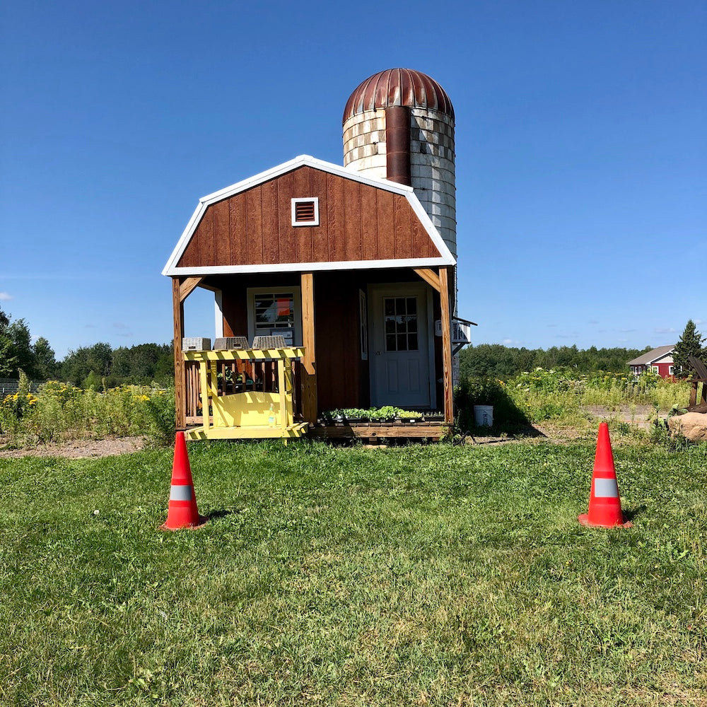 The Boreal Farm’s iconic barn and silo under a radiant sky on a summer day.
