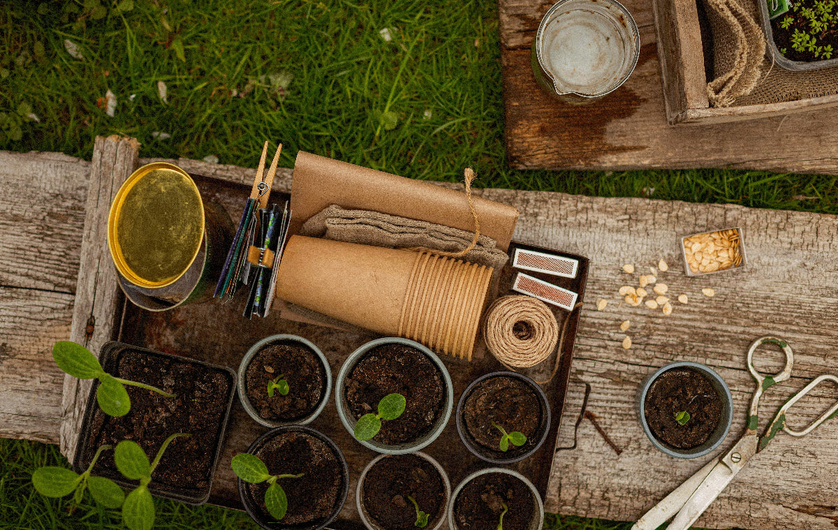 Gardening tools and supplies on a wooden table outdoors